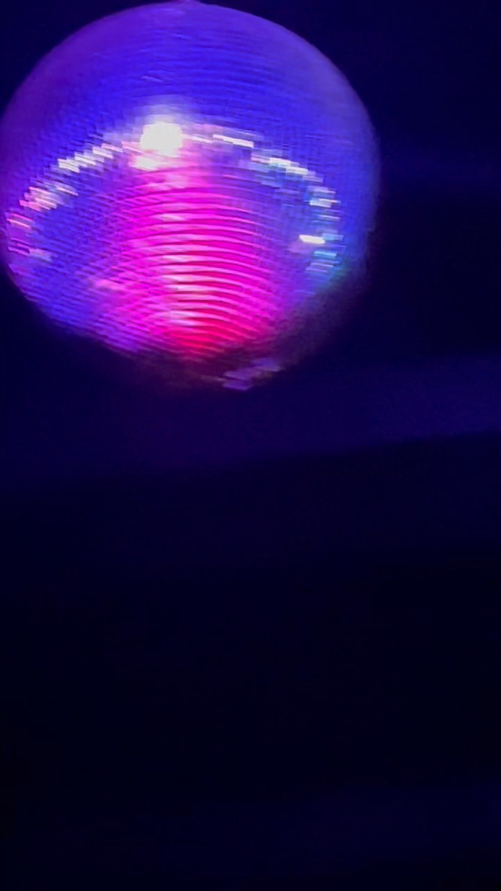 A spinning disco ball scattering light across the room